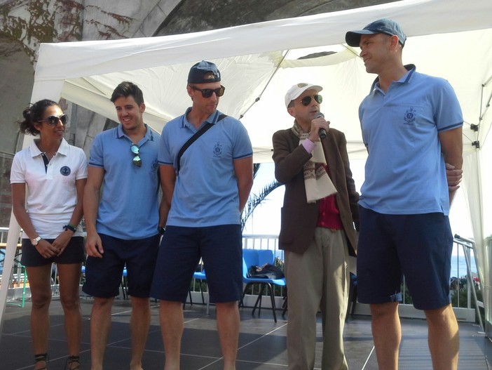 Nella foto di Tuttolevante.it l'equipaggio della Lni Rapallo, vincitore dell'ultima edizione del Palio marinaro del Tigullio, la scorsa estate, sul palco di Zoagli, insieme allo speaker ufficiale della manifestazione Gianrico Semorile